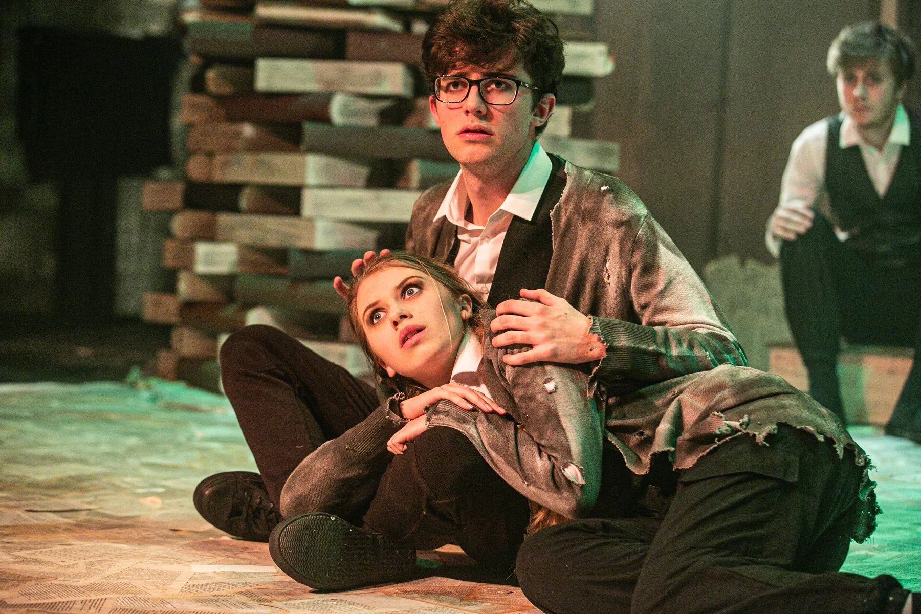 Billie-Jo as Gretel in Grimm's Tales. She has her head reasting on another actors lap. They both look scared.
